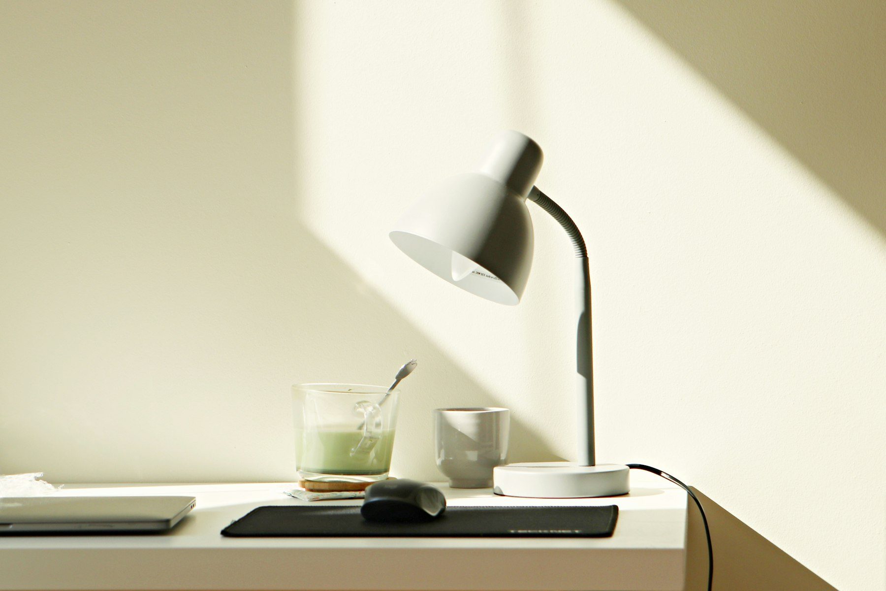 Heller Schreibtisch mit weißer Lampe im Sonnenlicht